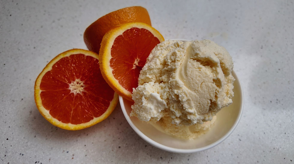 Creamy Cara Cara orange creamsicle ice cream served with fresh orange slices, showcasing a perfect blend of citrus and sweetness.