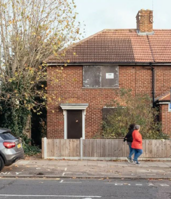 End of terrace brick home with boarded windows