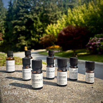 ARAU essential oil bottles arranged outdoors in a garden setting.