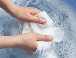 Top view of woman hand washing white clothing in suds, closeup.jpg