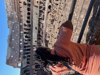 a woman looking at the Colosseum from inside the structure