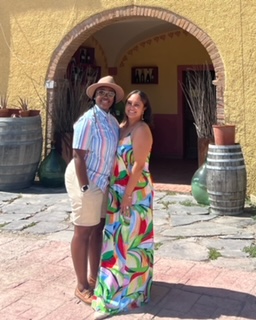 a lesbian couple standing in front  of the entrance to a winery