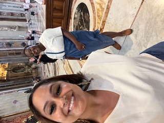 two wives inside of St. Peter's Basilica covered with wraps to hide exposed legs while wearing shorts
