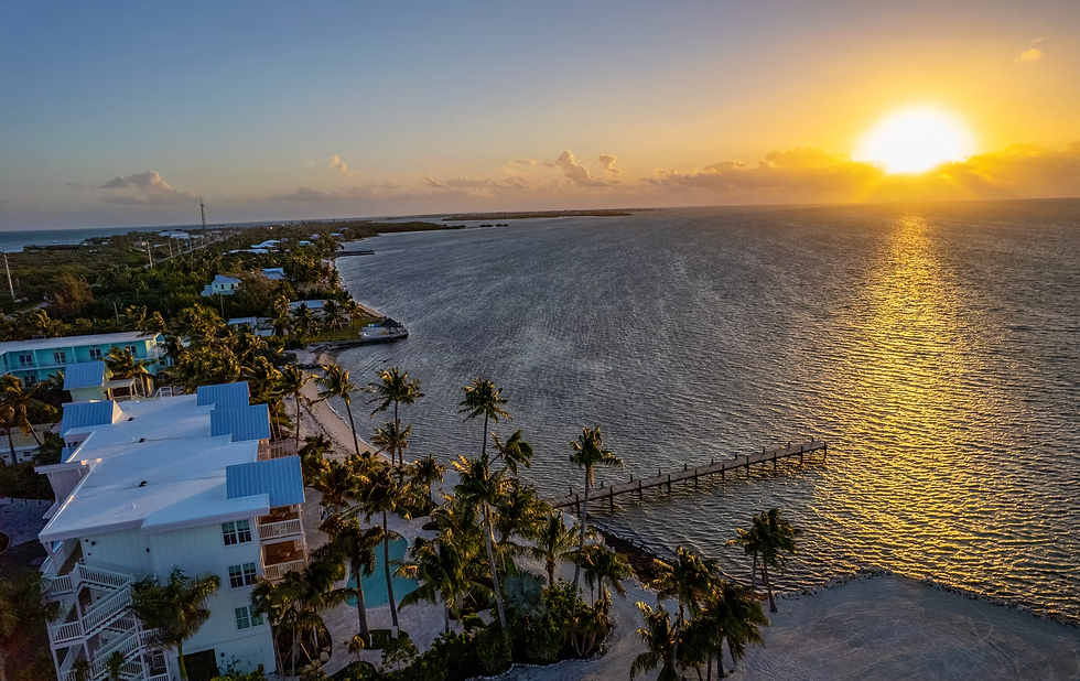 Aerial sunset view of Grassy Flats Resort in Marathon, Florida Keys with oceanfront rooms, dock, and fishing trip access