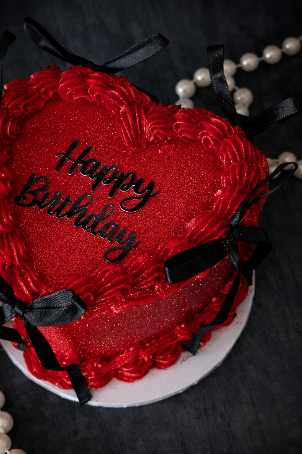 Red luxury buttercream heart cake with Lambeth piping, black satin bows and shimmer finish