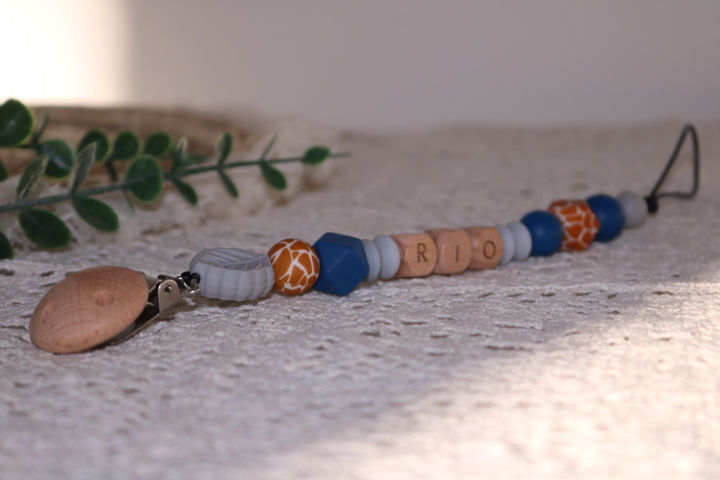 Speenkoord met grijze kleuren en grijs blad. Blauwtinten en giraffe print. Voorzien van naam in houten kralen