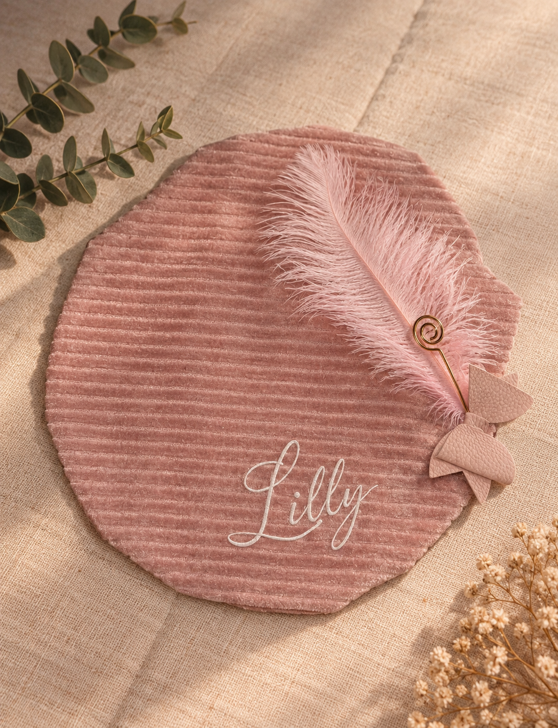 Zelf samengestelde licht roze pietenmuts van ribstof en velours met bedrukte naam gekleurde veer en decoratieve speld.