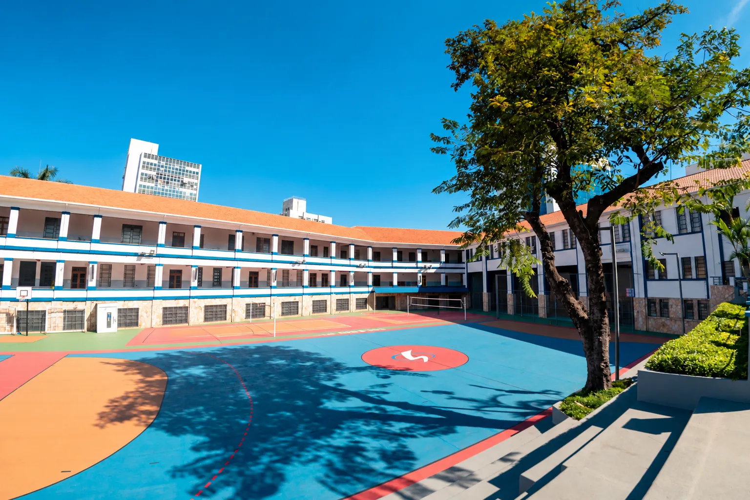 Área externa do Colégio Pio XII, com pátio aberto, quadras e árvores