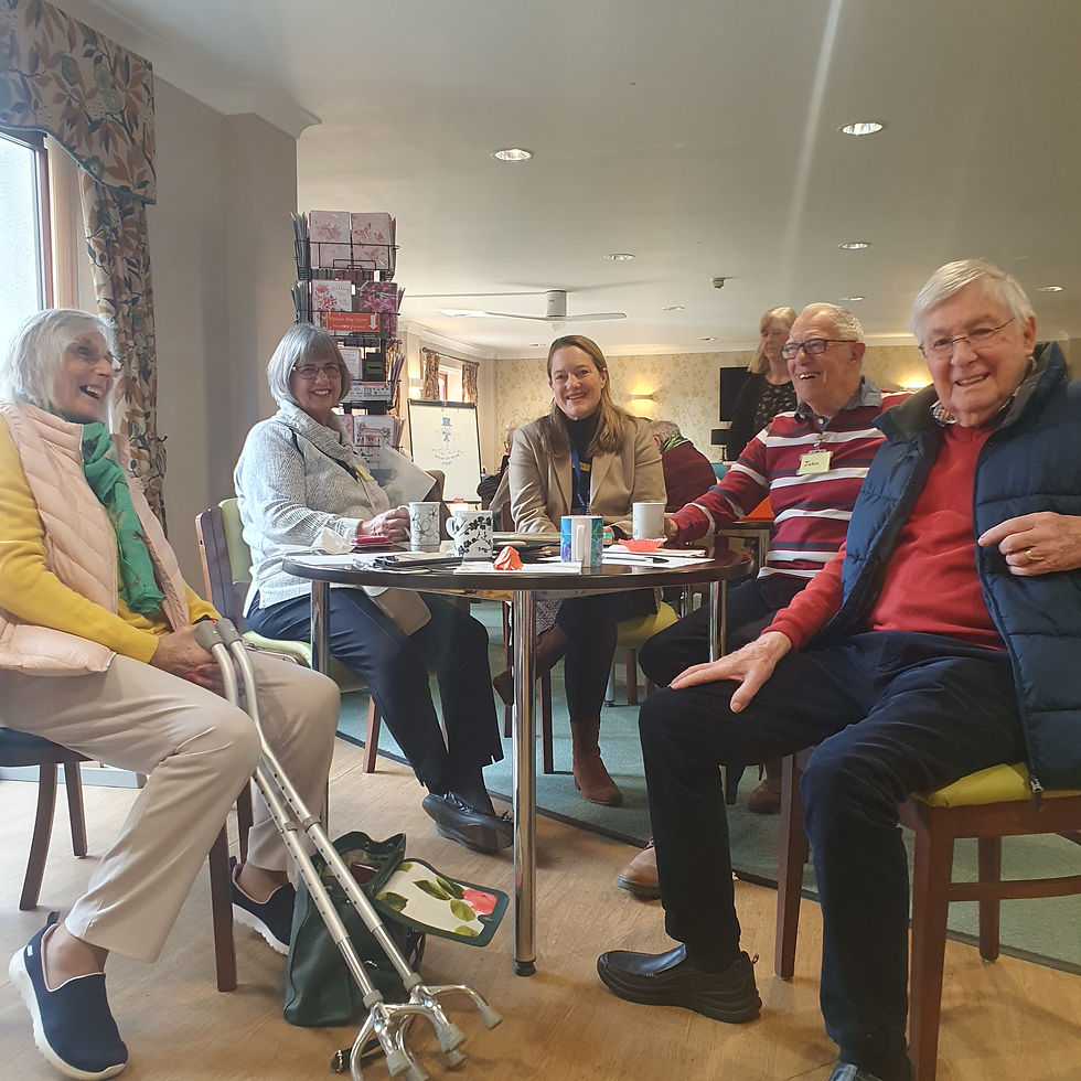 A Group of people living with dementia smiling in a care home