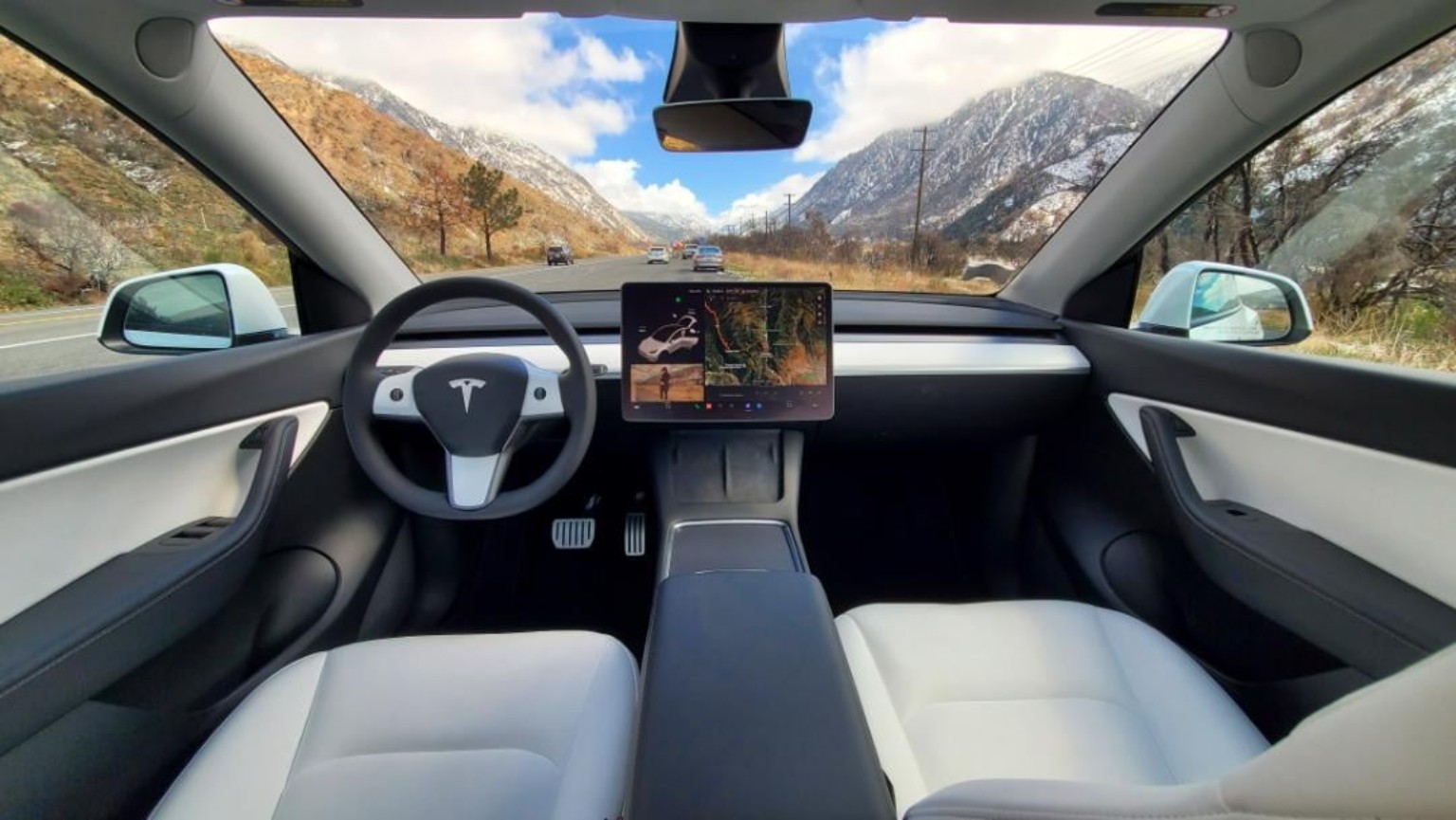 Tesla-style interior photograph: White-seat cockpit · Panoramic view