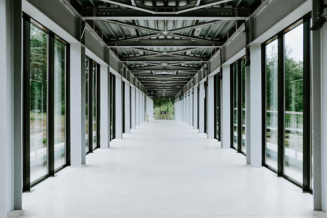 white-hallway-with-glass-doors-and-metal-ceiling-in-modern-building.jpg