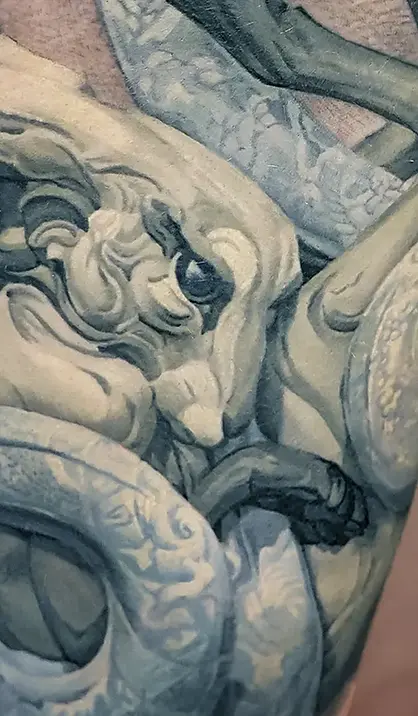 קעקוע ריאליזם של ארנב ונחש בהשראת פיסול של בת׳ קוונר על הירך.