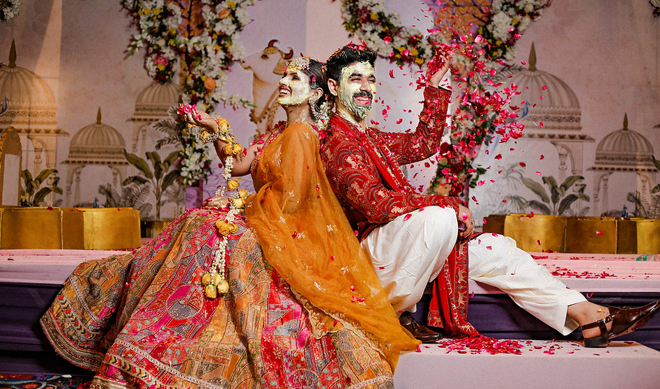 Candid bride and groom moments captured during a colorful flower-filled haldi ceremony