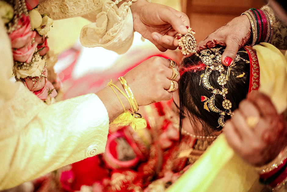 Groom applying sindoor during the wedding ceremony