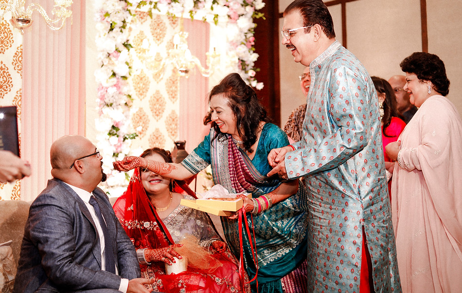 A candid loving moment captured between the groom & parents.