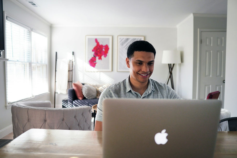 man sitting at a table in front of a laptop