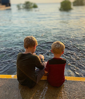 kids on waters edge at sunset
