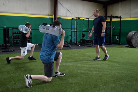 Water weights squat walk during personal training at Edge Fitness GVL in Greenville, South Carolina
