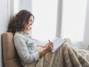 A lady reflecting and writing in a journal