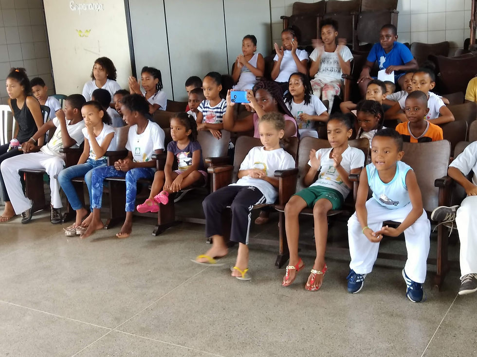 Crianças assistem atentas apresentação de capoeira