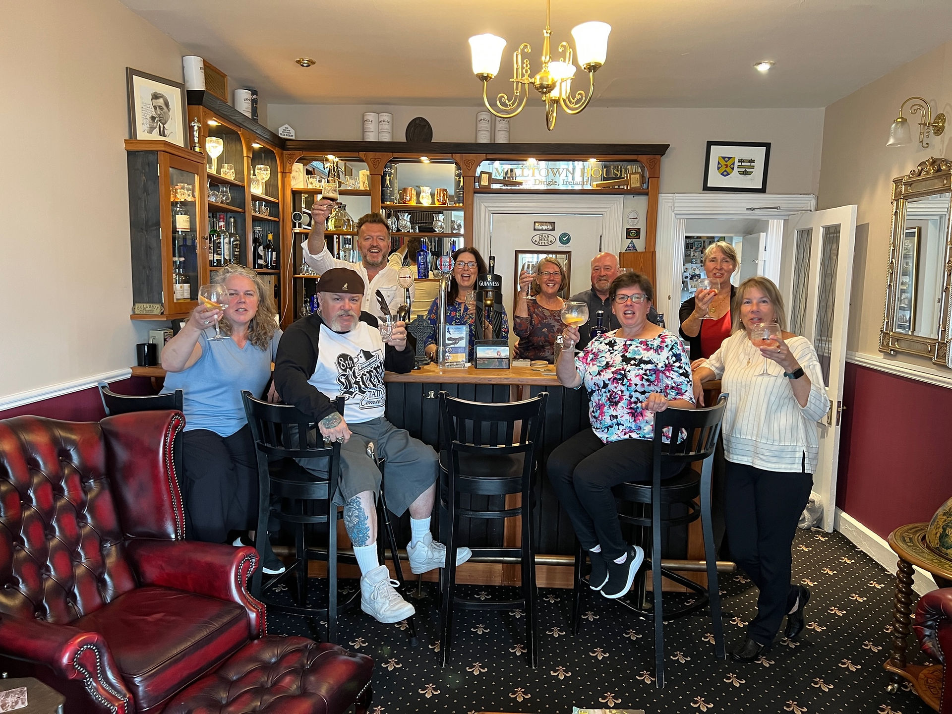 Group of people smiling and gesturing thumbs up at a bar.