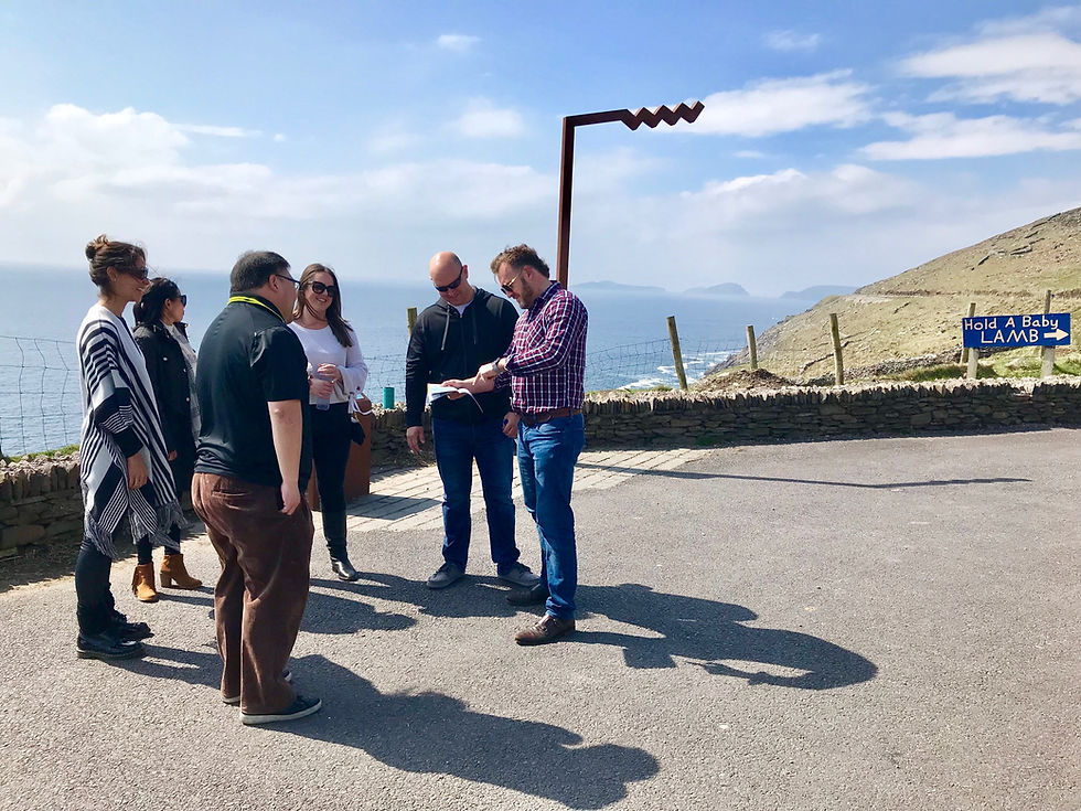 Group of people reviewing documents on a scenic Ireland tour by Essential Ireland Tours.