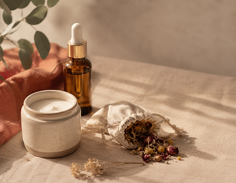 Natural skincare products with serum, cream, and dried herbs