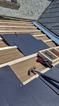 Roof repair in progress: slate tiles, tools