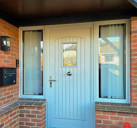 Grey front door and windows with visible text, house exterior setting