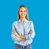 Smiling woman in light blue shirt with arms crossed