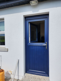Blue UPVC Door with glass panel, white building background, exterior view.