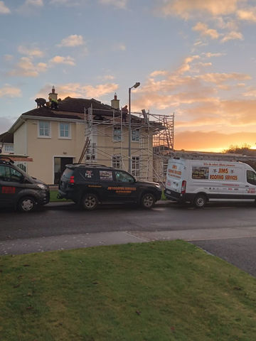 House with scaffolding on a dramatic sunset