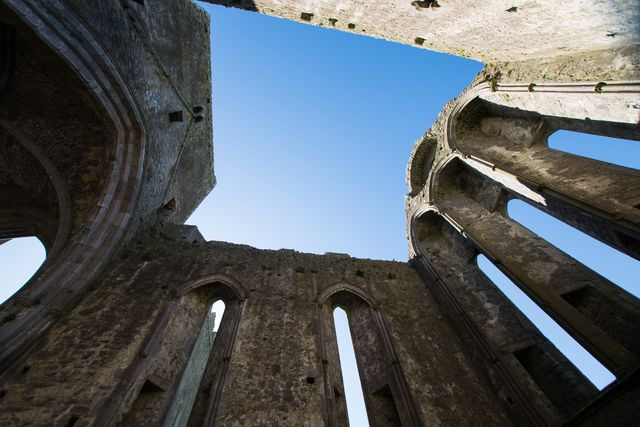 Looking up at the sky through an ancient stone structure. Essential Ireland Tours