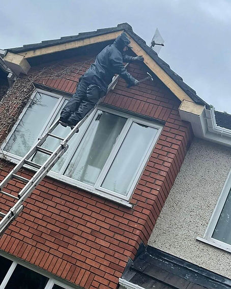 Worker on ladder installing roofline