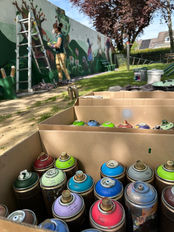 Spraydosen und Leiter vor Spielplatzwand