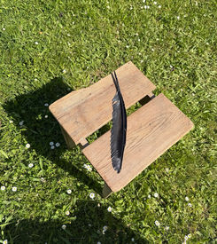 Feder auf Sitzfläche eines Hockers aus Holz