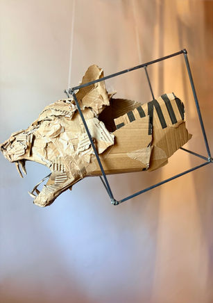 Skulptur eines brüllenden Panterkopfes aus Karton in einem Stahlkubus