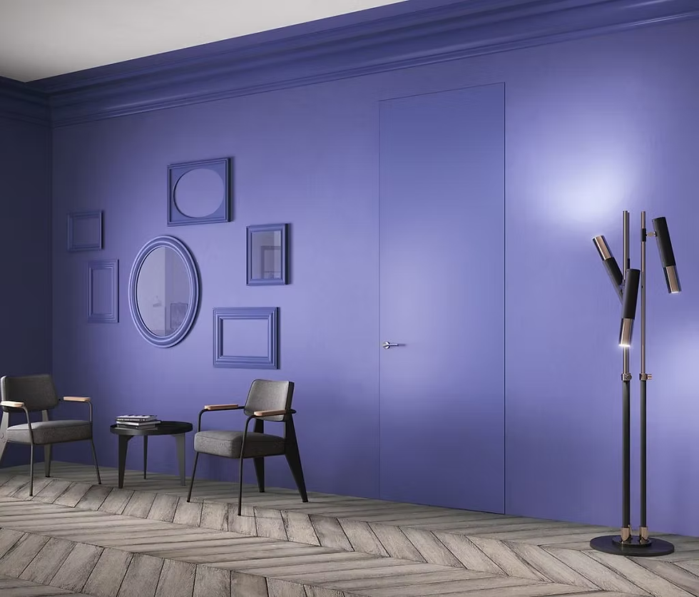 Interieur met muren, kozijnen en deur in Very Peri-blauw, ingericht met twee grijze stoelen, een zwarte lamp en een ronde spiegel. De ruimte laat zien hoe de Pantone Color of the Year 2022 een gevoel van vernieuwing en optimisme brengt door kleur op wanden en details te verbinden.