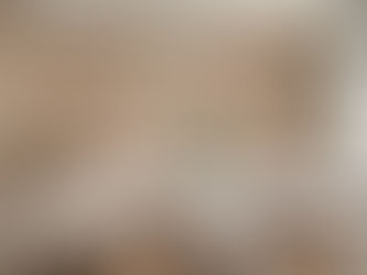 een kamer met een gedekte tafel een wit tafelkleed, houten eetstoelen de setting is cottage core met behang met grote objecten bijvoorbeeld een rode radijs een courgette een aubergine een advocado op de tafel staan glazen een een vaas met bloemen