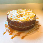 2 tier caramel apple carrot cake moist with a soft crumb topped with cream cheese frosting and caramel sauce drizzled across