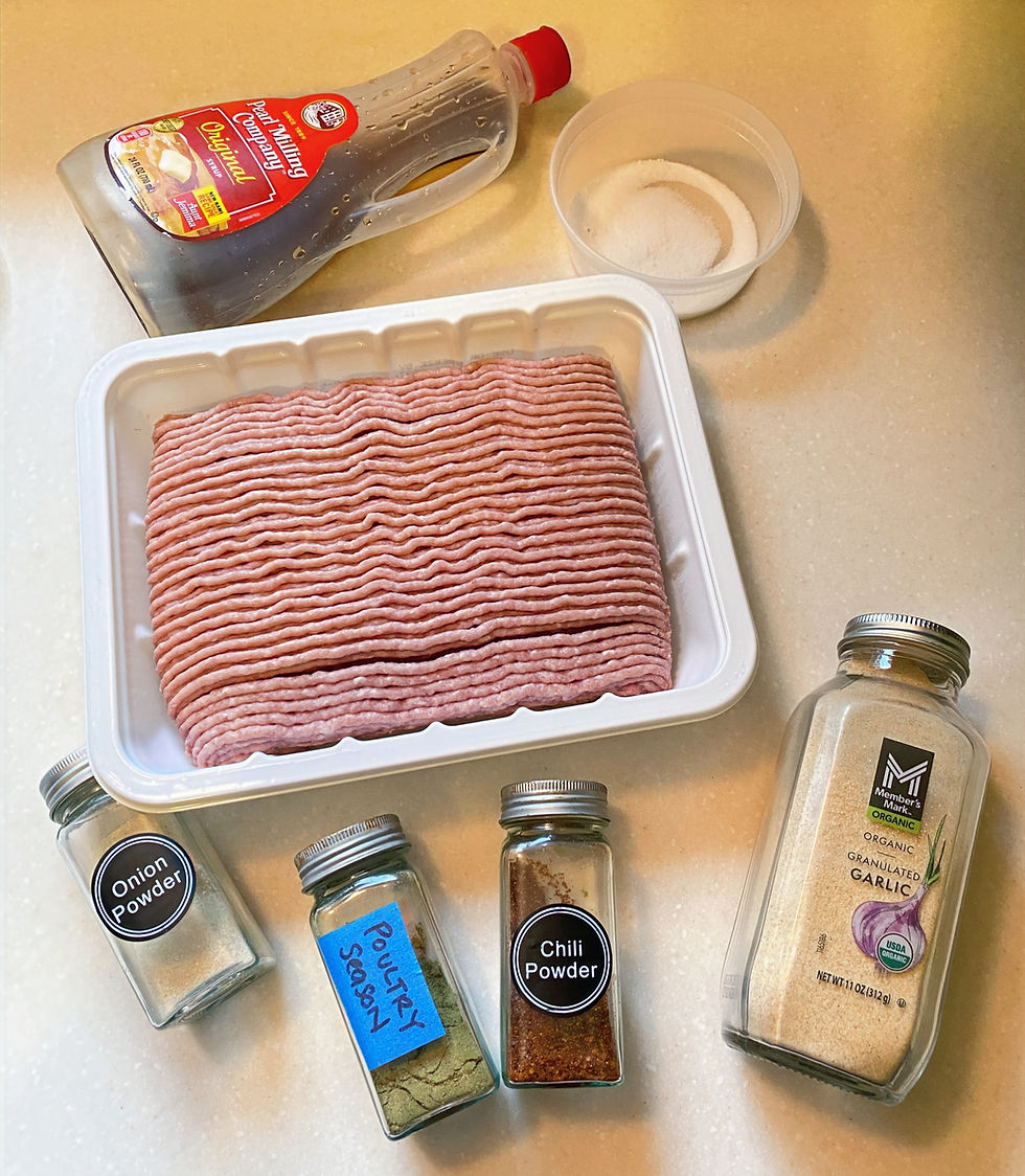 a top down view of the ingredients needed to make maple sausage breakfast patties including ground turkey, maple syrup, salt, poultry seasoning, garlic, onion, and crushed red pepper flakes