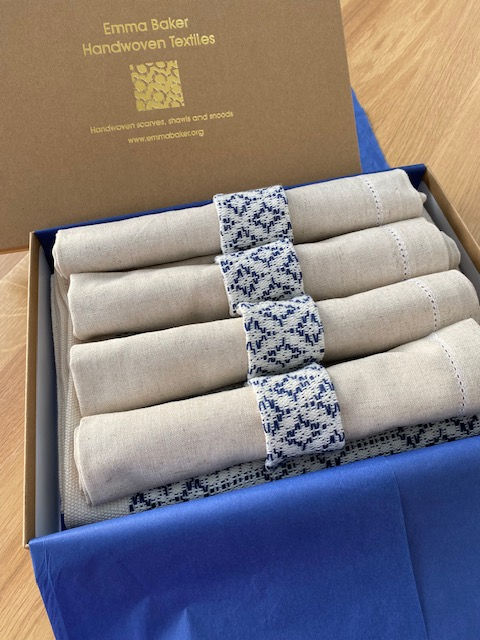 Thumbnail: brown gift box with navy blue and natural patterned table mats and napkins