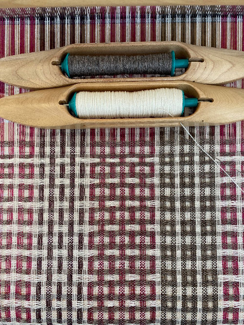 Thumbnail: handwoven pink and white merino lambswool scarf being woven on a floor loom