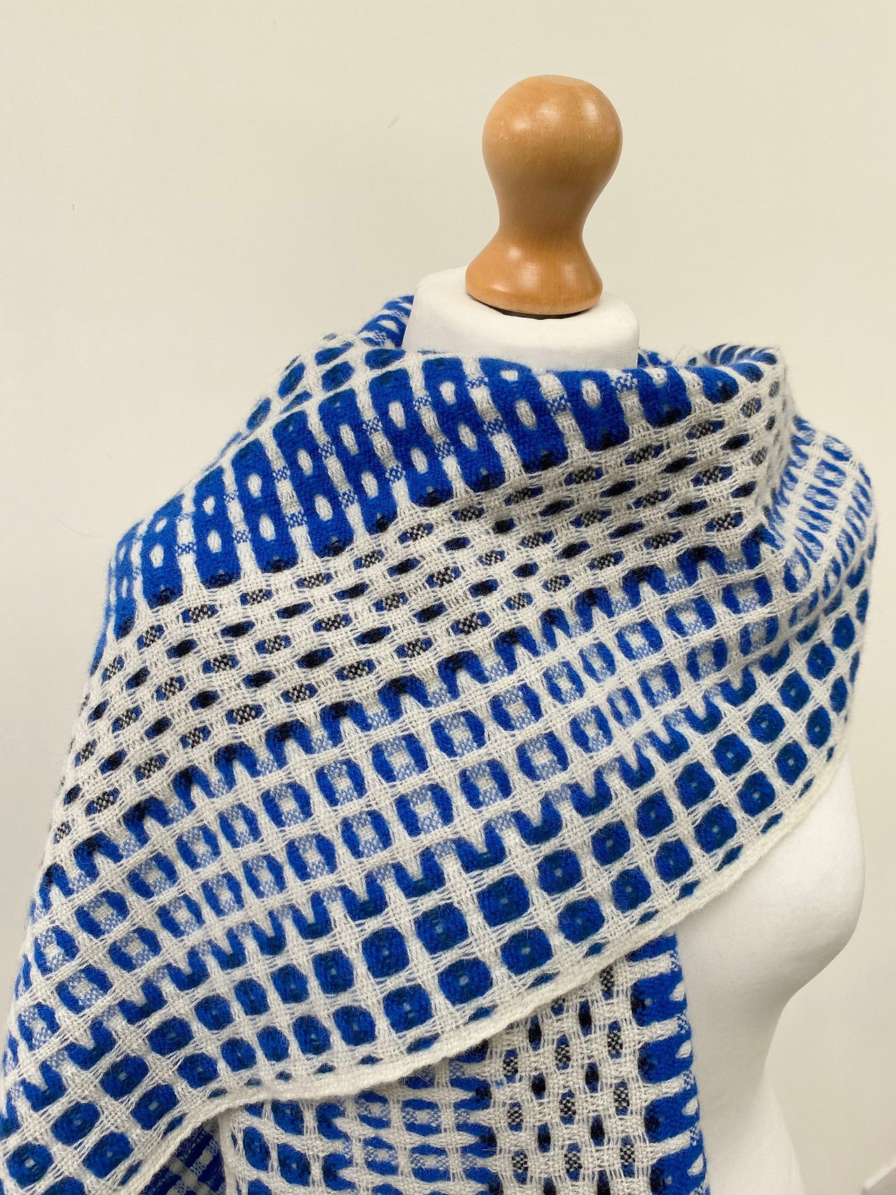 Handwoven electric blue scarf wrapped around models shoulders