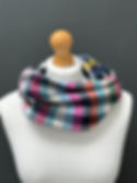checked multicoloured merino wool snood scarf on a mannequin against a dark grey wall