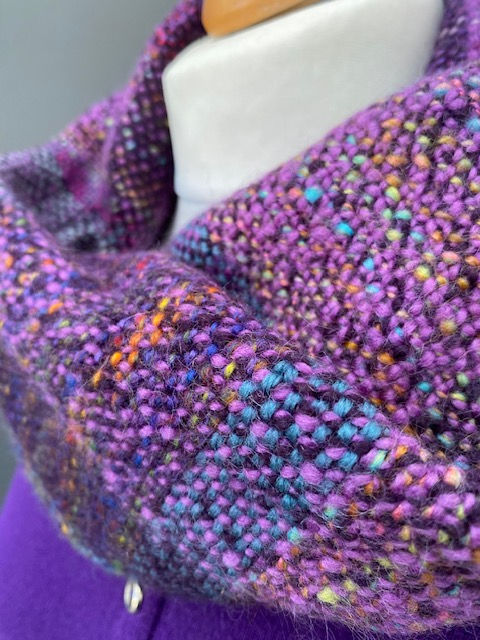 close up view of a purple, pink, handwoven snood scarf woven with handspun merino yarn
