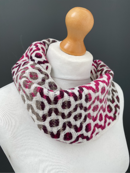 Thumbnail: pink and white handwoven snood scarf on  a mannequin against a dark grey wall