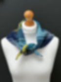navy blue and yellow merino wool large checked triangle scarf on a mannequin against a dark grey wall