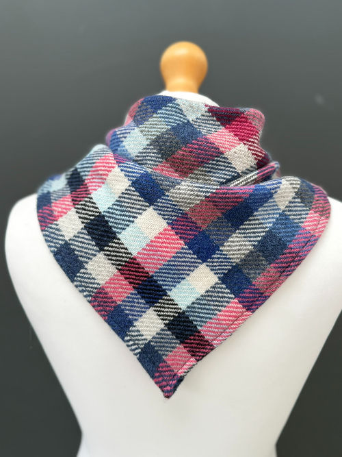 Thumbnail: checked blue pink and navy wool triangle scarf on a mannequin against a dark grey background