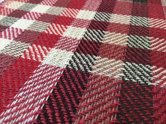 red, green and beige twill weave on the floor loom